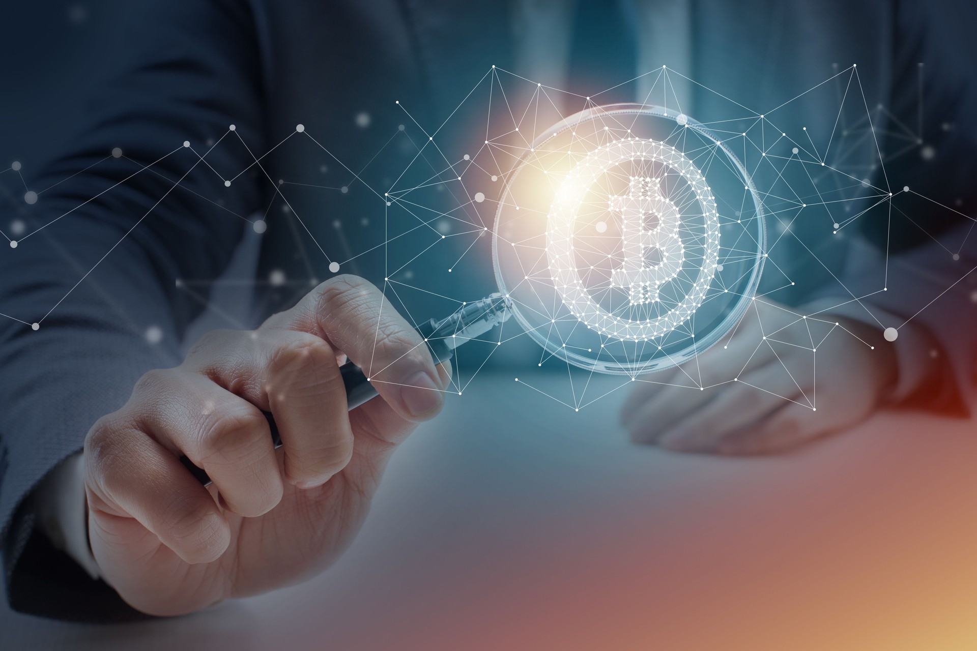 Businessman at Desk Looking Through Magnifying Glass at Bitcoin Symbol